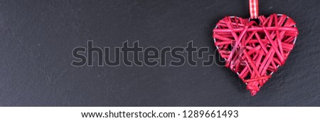 One red love heart isolated on black background