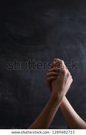 hands of people in symbol of relationships, black background, hand in hand