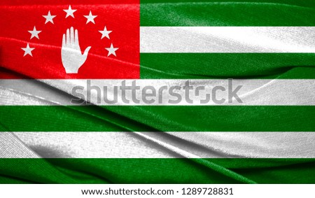 Realistic flag of Abkhazia on the wavy surface of fabric. Perfect for background or texture purposes