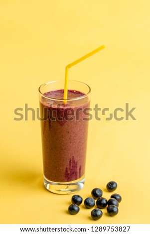 purple drink from berries on the isolated yellow background. vitamins, wellbeing