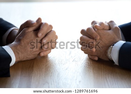 Clasped hands of two business men negotiators opponents opposite on table as politicians dialogue debate, applicant hr job interview, negotiating competitors, rivals confrontation challenge concept Royalty-Free Stock Photo #1289761696