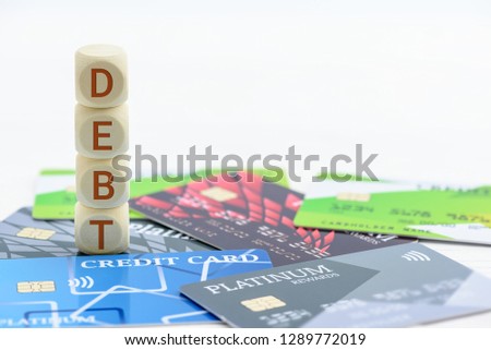 Credit card debt  unsecured consumer debt concept : Wood cubes  dices on credit cards, depicts the results of not paying money on time, late payment penalty will be charged and had bad credit rating Royalty-Free Stock Photo #1289772019