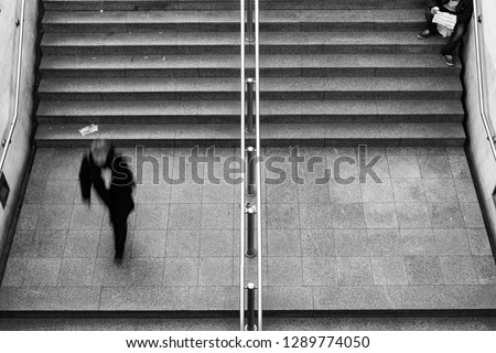 beggar siting on stairs in metro station in Athens