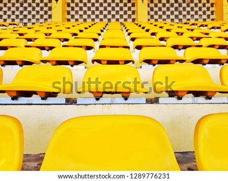 Yellow color chairs on the stand cheer in a row line. Nobody view on seats on amphitheature.