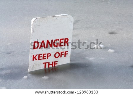 Danger Keep off the Ice sign partly submerged in a lake.