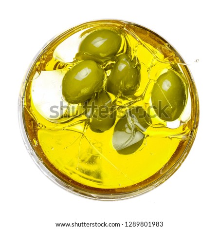 Green olives splash in olive oil, close up, top view