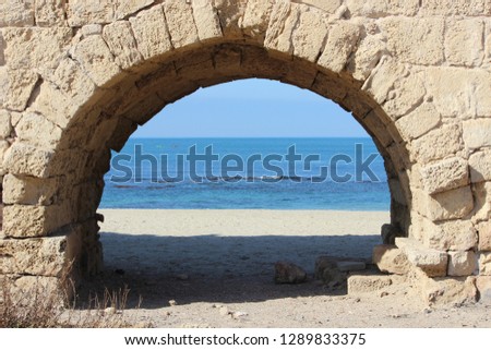 Sea through arch of old aqueduct in Israel 