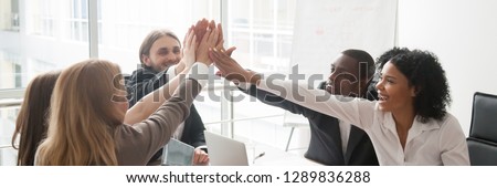 Multi-ethnic business people sitting at desk boardroom celebrating success giving high five feels happy excited, team spirit unity concept. Horizontal panoramic photo banner for website header design
