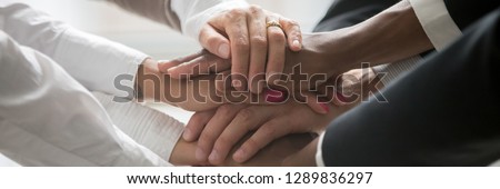 Close up multiracial business people stack holds their hands together as symbol gesture concept of unity togetherness assistance and support horizontal panoramic photo banner for website header design