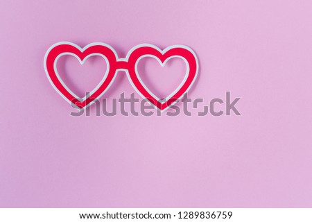 Photo booth props glasses on pink background. Heart shaped red glasses. Valentines day , Birthday or Party set. Top view. Flat lay. Copy space.