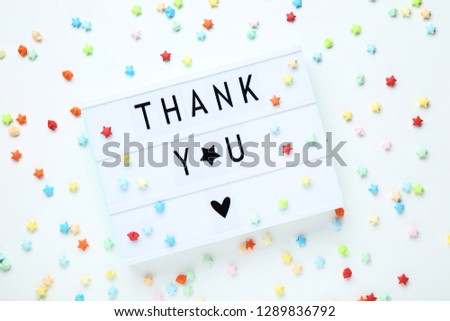 Lightbox with words Thank You and colorful paper stars on white background