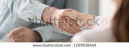Businessman shaking hands with businesswoman, client and agent greeting gesture. Two people handshaking expressing respect and trust concept. Horizontal close up photo banner for website header design