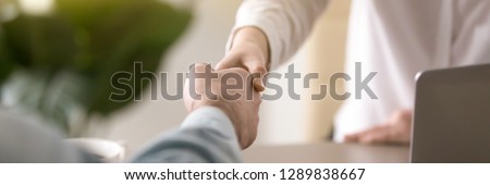 Horizontal photo businesspeople shaking hands, greeting or farewell at business negotiations, client and company representative handshaking, symbol gesture of respect banner for website header design