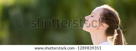 Horizontal conceptual photo profile portrait relaxed woman face closed eyes breath fresh clean air outdoors enjoying nature weather feels good banner for website header design with copy space for text