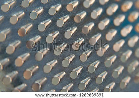 A part of an old grater for food. The old grater is no longer used, but as a background for an interesting idea it may be suitable.