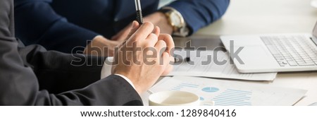 Horizontal photo businessmen during meeting brainstorm negotiate use charts graphs sales analyse stats shown at paper document share thoughts ideas. Teamwork concept, banner for website header design Royalty-Free Stock Photo #1289840416