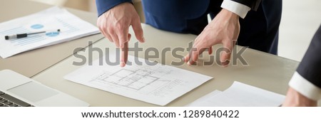 Horizontal photo businessman and architect negotiating, close up hand points on paper project plan building, construction industry and pricing of real estate concept, banner for website header design