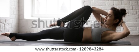 Horizontal photo woman wearing black panties grey bra lying on mat doing bicycle crunches criss cross fitness exercise at sport center or home banner for website header design with copy space for text