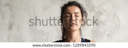 Horizontal photo beautiful woman face with closed eyes practicing yoga breath meditate feels calmness. Physical and mental healthcare concept, banner for website header design with copy space for text Royalty-Free Stock Photo #1289843290