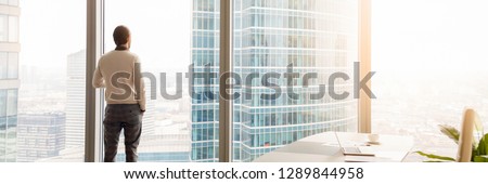Horizontal photo rear back successful businessman look through window at big city, rest has break, think about future business vision concept, banner for website header design with copy space for text