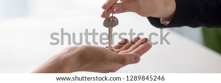 Horizontal close up photo with copy space for text real estate agent hand giving keys from property to owner, buying selling home, loan mortgage, renting tenancy concept banner website header design
