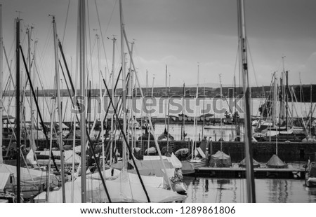 A picture of an old dock filled with sailing boats of all shapes and sizes.