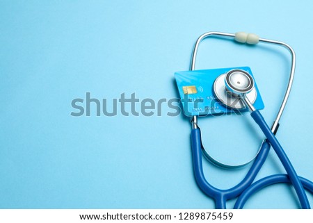 Credit card with stethoscope on blue background. The concept of medical strechevka or expensive medicine, doctors salary. Copy space for text Royalty-Free Stock Photo #1289875459