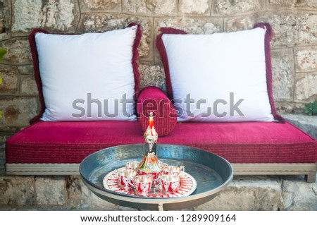 Coffee set on a table in front of sofa. Cup of tea on a tray on a round table with sofa in living room at home.