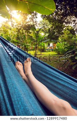 slender legs of a girl lying in a hammock in the tropical jungles of Brazil. Brasil
