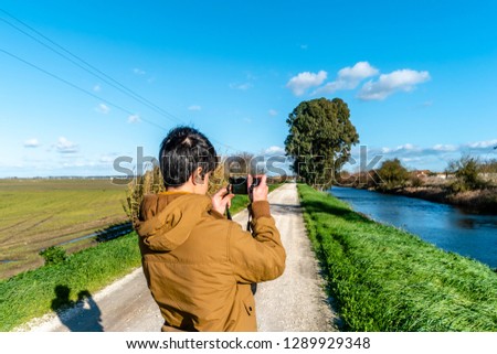 young man taking picture on natural background