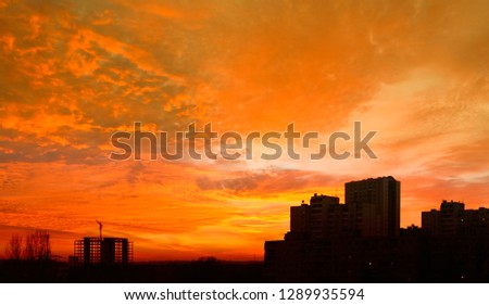Photo dawn in the city. In the frame of large residential buildings, construction, crane. Picture taken in Ukraine. Kiev region. Horizontal frame. Color image toning