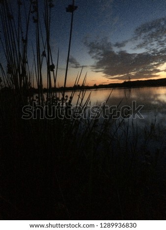 A colorful picture of the sunset by a nice lake