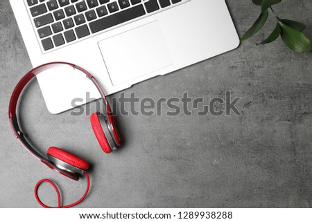 Flat lay composition with headphones, laptop and space for text on grey background