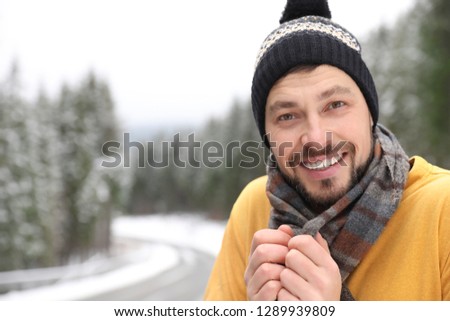 Man in warm clothes outdoors, space for text. Winter vacation