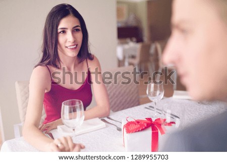Valentine's Day concept. Happy couple in love with. A young loving couple celebrating Valentine's Day in the restaurant. Lovers give each other gifts. Romance restaurant for Valentine's Day- concept 