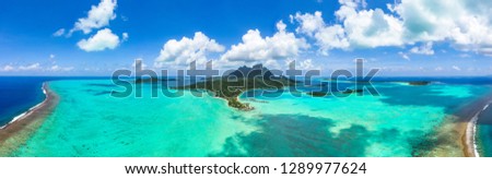 Panorama aerial view of Bora Bora island, Tahiti, French Polynesia, Matira point with overwater bungalows of a luxury resort and Mount Otemanu with amazing turquoise lagoon. Holiday dream. Paradise Royalty-Free Stock Photo #1289977624