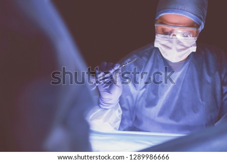Cropped picture of scalpel taken doctors performing surgery.