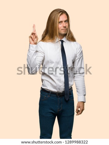 Blond businessman with long hair with fingers crossing and wishing the best on isolated background