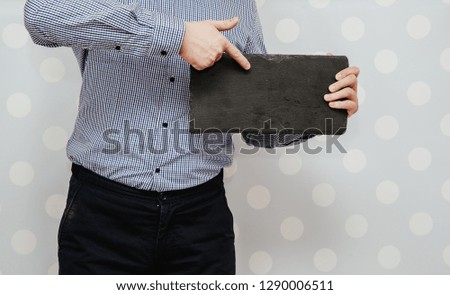 Businessman holds in his hands an empty stone tablet. Content completion concept. The man gives information, entering his own content.