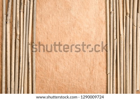 Dried reeds in a row on wooden background.