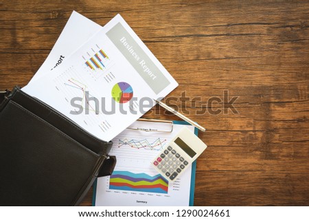 Business report chart preparing graphs on briefcase bag / Summary report in Statistics circle Pie chart on paper business document financial and calculator pen on the wooden table background