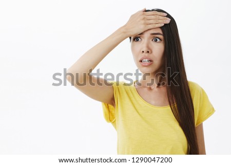 Woman remembered important thing she forgot do feeling anxious and concerned punching forehead with palm staring left worried and stunned being anxious and troubled over gray background