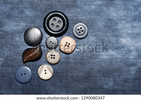 Texture of worn denim fabric with multi-colored sewn buttons for backgrounds.Jeans