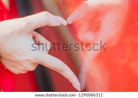 The sign, heart shaped fingers reflect mirror for lovers on Valentine's day, happy , blurred , soft focus.