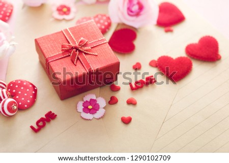 Valentine Day gift box with red hearts and roses on letter envelope.