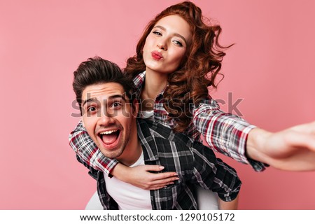 Beautiful curly woman making selfie with husband. Excited couple celebrating valentine's day.