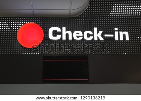Check in desk at international airport, checkin counter and monitor for flight information display, red round sign close up, layout for passenger air transportation and flight ticket registration