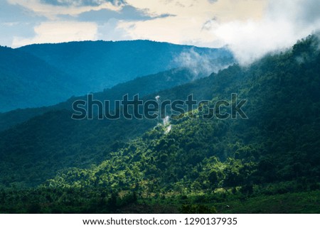 Beautiful sunrise with fog and sunlight in the forest mountain in Bao Loc, Vietnam.