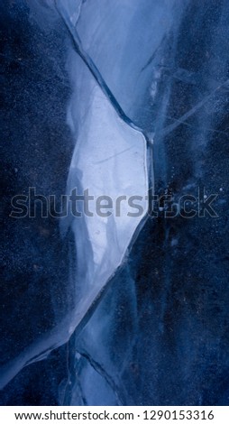 The frozen lake surface, showing a variety of textures. Blue background of Ice texture. 16:9 frame picture.
