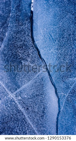 The frozen lake surface, showing a variety of textures. Blue background of Ice texture. 16:9 frame picture.